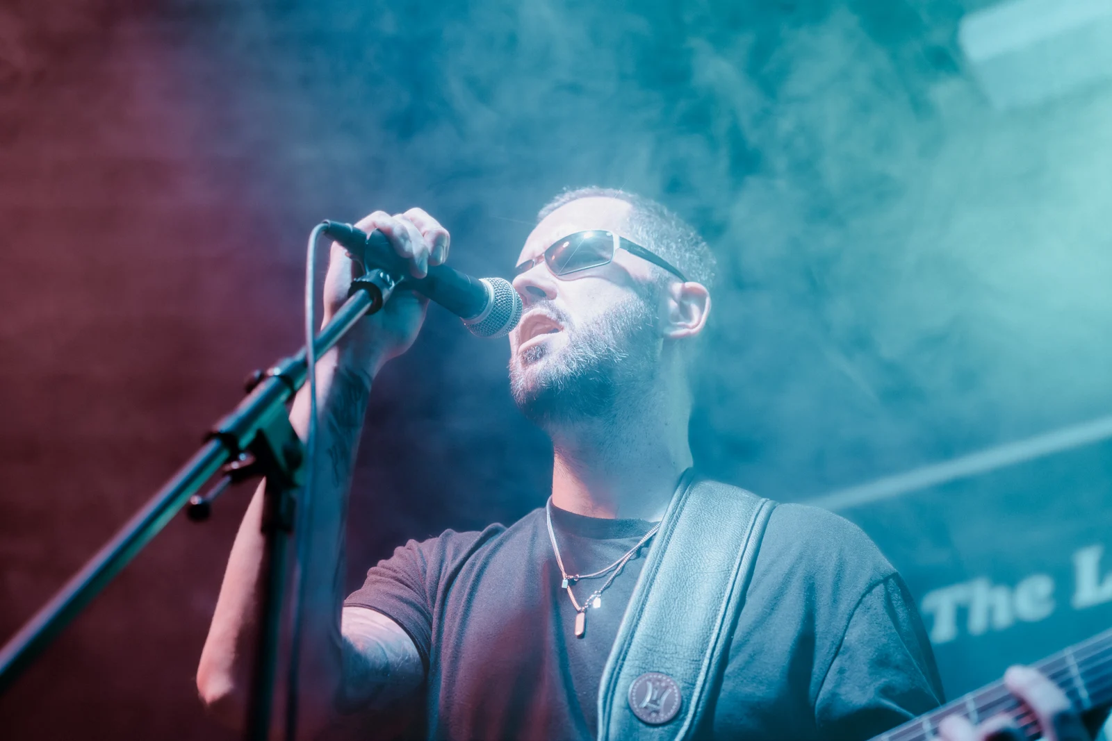 Pete singing into the microphone under the stage lights at the Fiddler's Elbow